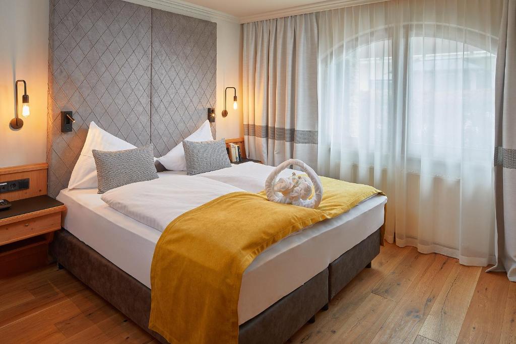 Postel nebo postele na pokoji v ubytování Sporthotel Ellmau in Tirol