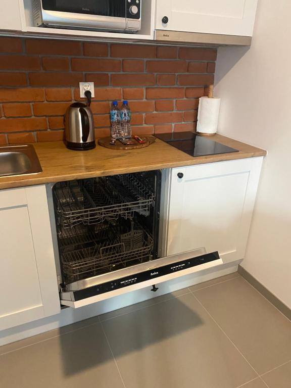 Kuchyň nebo kuchyňský kout v ubytování Apartamenty BRUNO i BIANCA w Symphony Modern Tower Gdynia 2 i 3 piętro