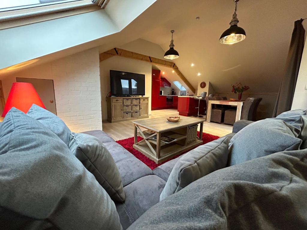 un soggiorno con divano e tavolo di Race & Rooms Appartment a Stavelot