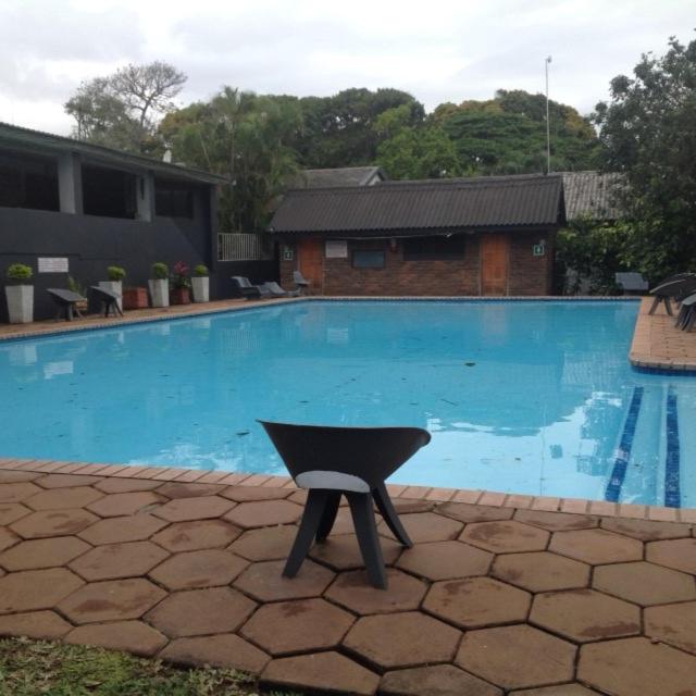a black chair sitting in front of a swimming pool at For your family Manzini 1 in St Lucia