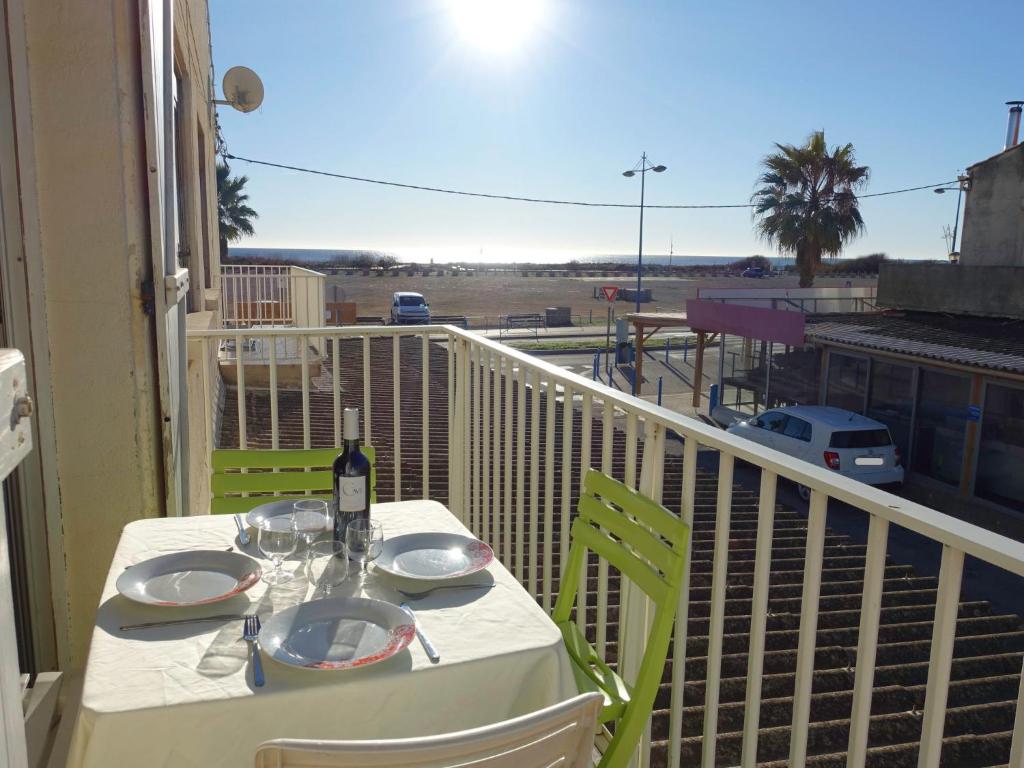 a table with a bottle of wine on a balcony at Apartment Vicente by Interhome in Saint Pierre La Mer