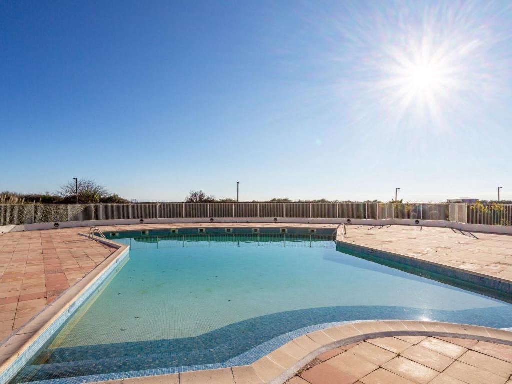 a large swimming pool with blue water at Apartment Le Sunset-Cap Sud-12 by Interhome in Cap d'Agde