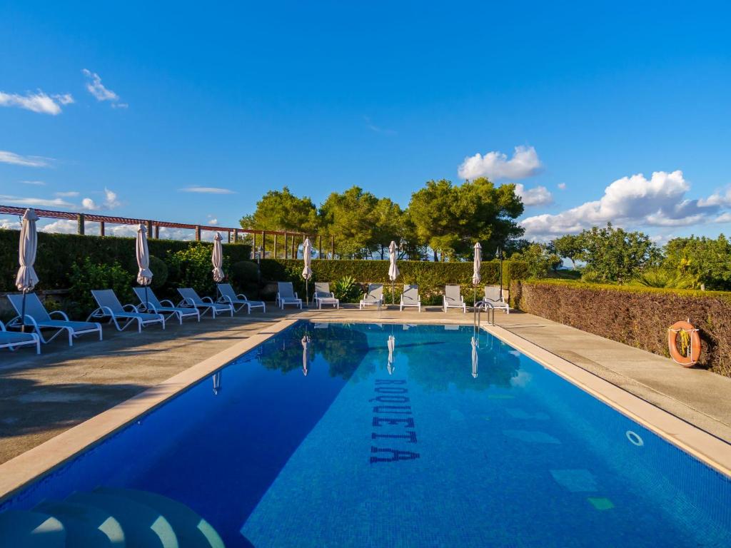 a swimming pool with chairs and umbrellas at Apartment Agroturismo Roqueta - MDS101 by Interhome in Maria de la Salut