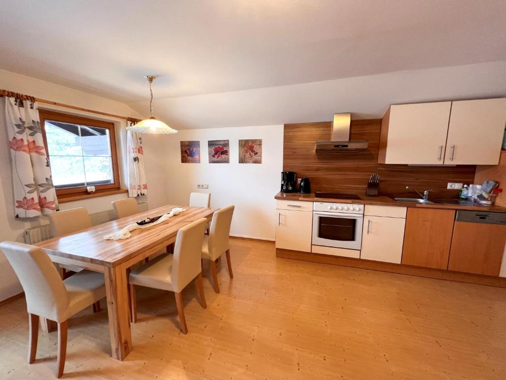 uma cozinha e sala de jantar com mesa e cadeiras de madeira em Apartment Haslinghof by Interhome em Piesendorf