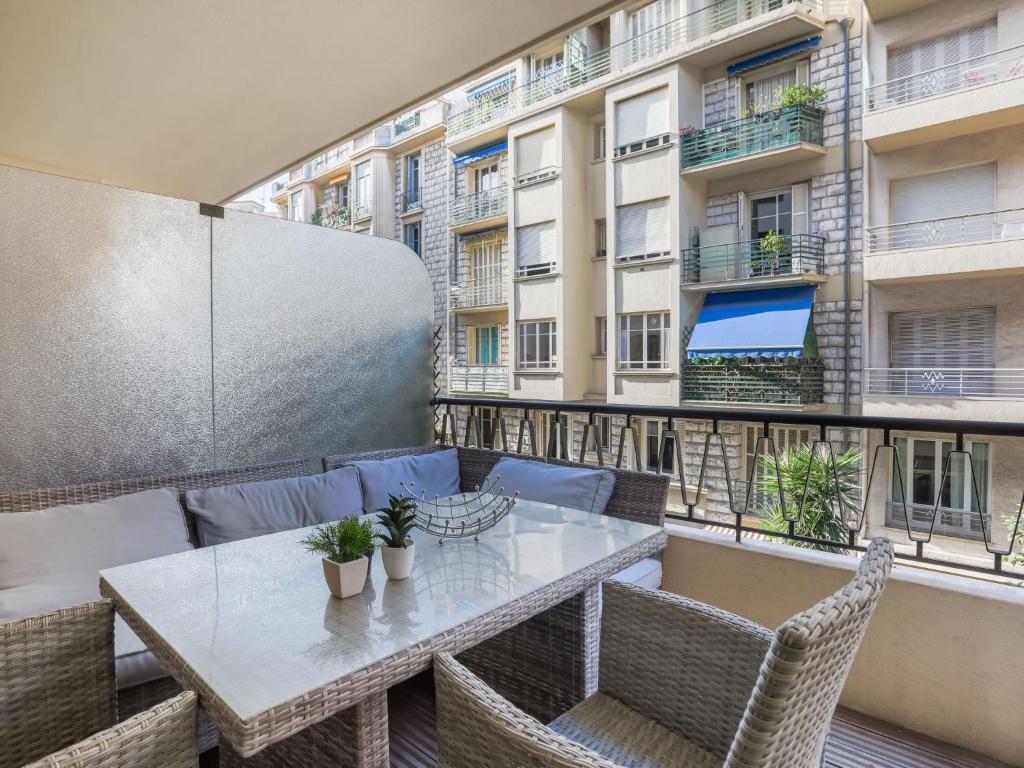 einen Tisch und Stühle auf einem Balkon mit einem Gebäude in der Unterkunft Apartment Héraclès by Interhome in Nizza