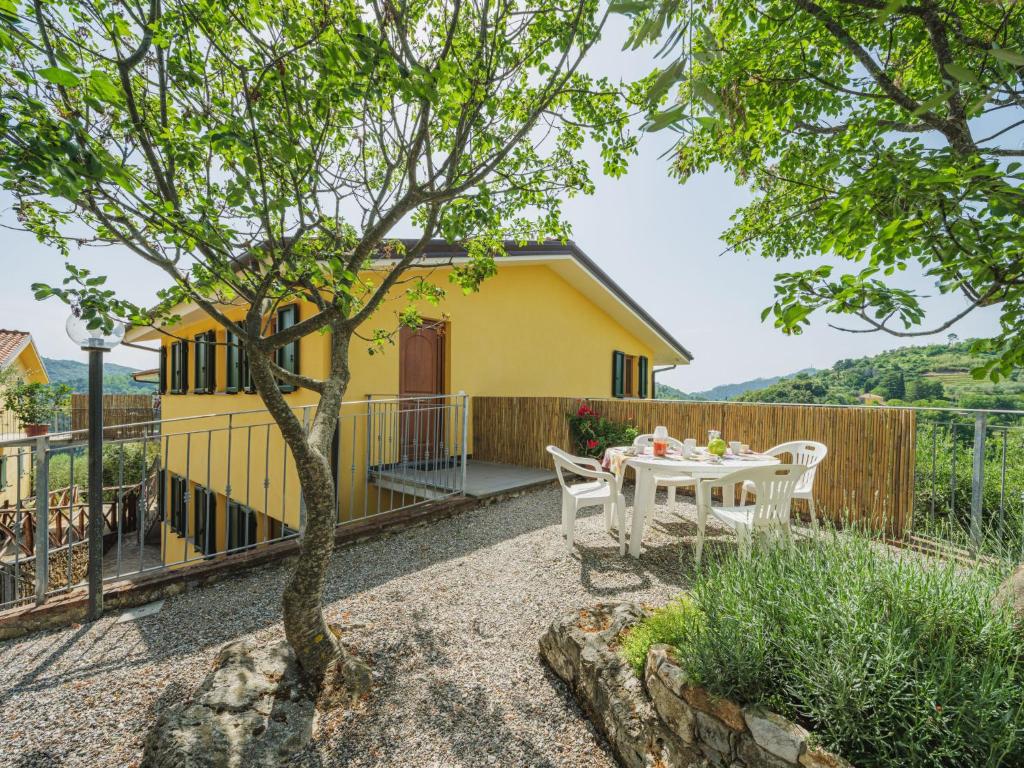 un jardín con mesa y sillas y una casa amarilla en Apartment Ca` del Lovi-1 by Interhome, en Chiatri