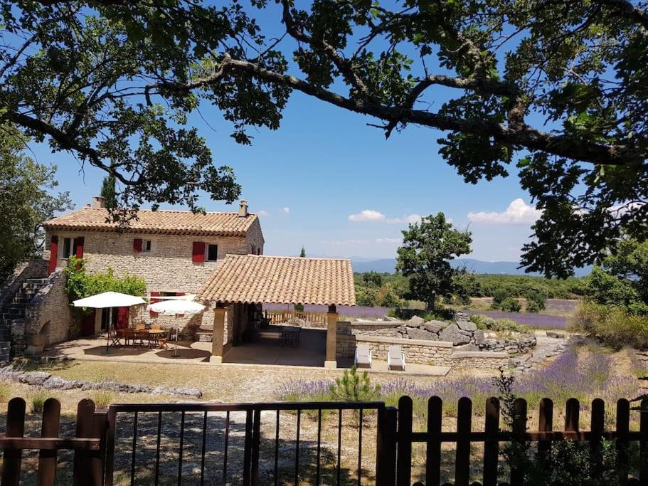 dom z płotem przed nim w obiekcie Maison de caractère dans Luberon avec piscine w mieście Saignon