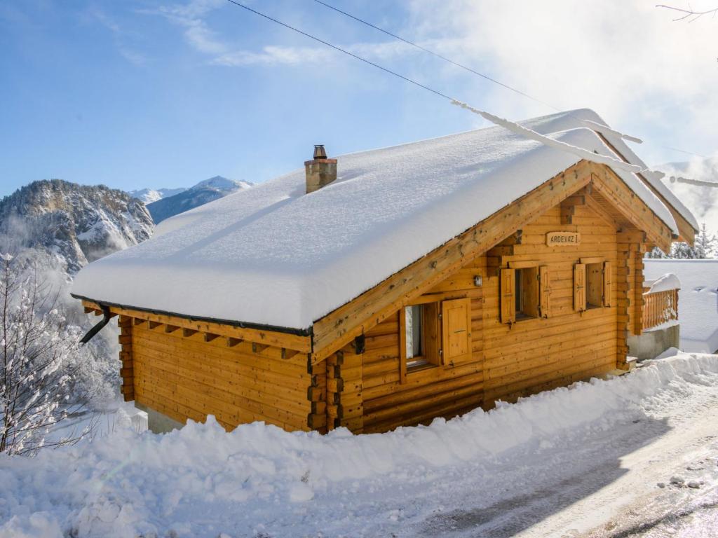 オヴロナにあるChalet Ardévaz I by Interhomeの屋根に雪が積もった木造キャビン