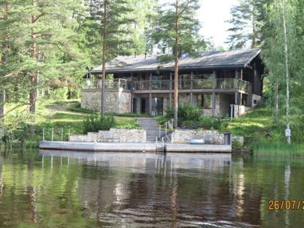 uma grande casa sentada na água perto de um lago em Holiday Home Villa pinjaranta by Interhome em Tahkovuori