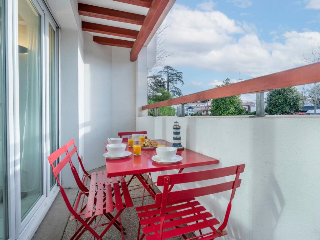 uma mesa vermelha e cadeiras numa varanda em Apartment Argia Eder by Interhome em Saint-Jean-de-Luz