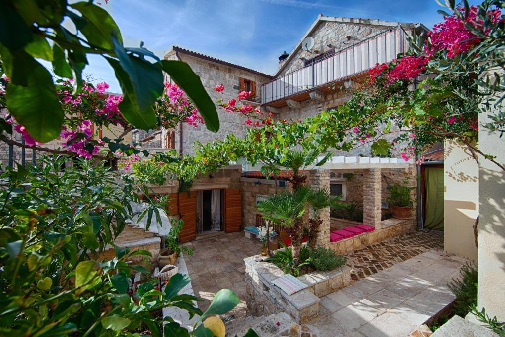 una vista exterior de una casa con flores en Villa Alma Komiza Island Vis en Komiža