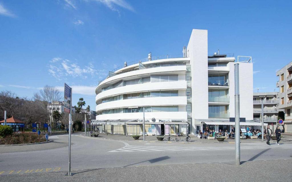 un gran edificio blanco con gente encima en Apartamento Ancora en primera línea de la playa, en Tossa de Mar