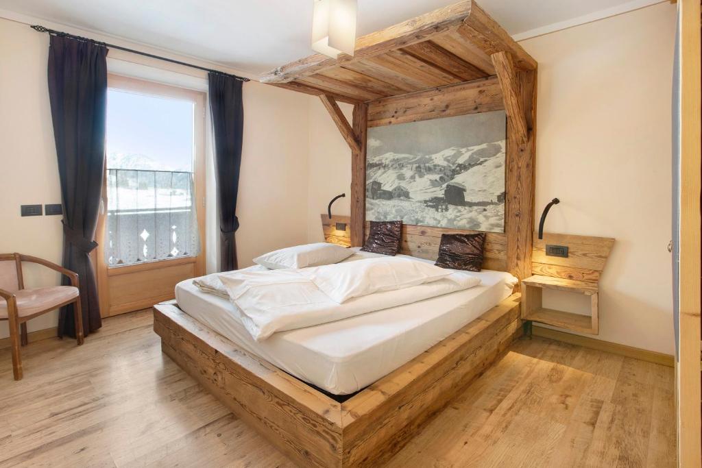a bedroom with a large bed with a wooden headboard at Appartamento1 deluxe - Alpen Suite in Livigno