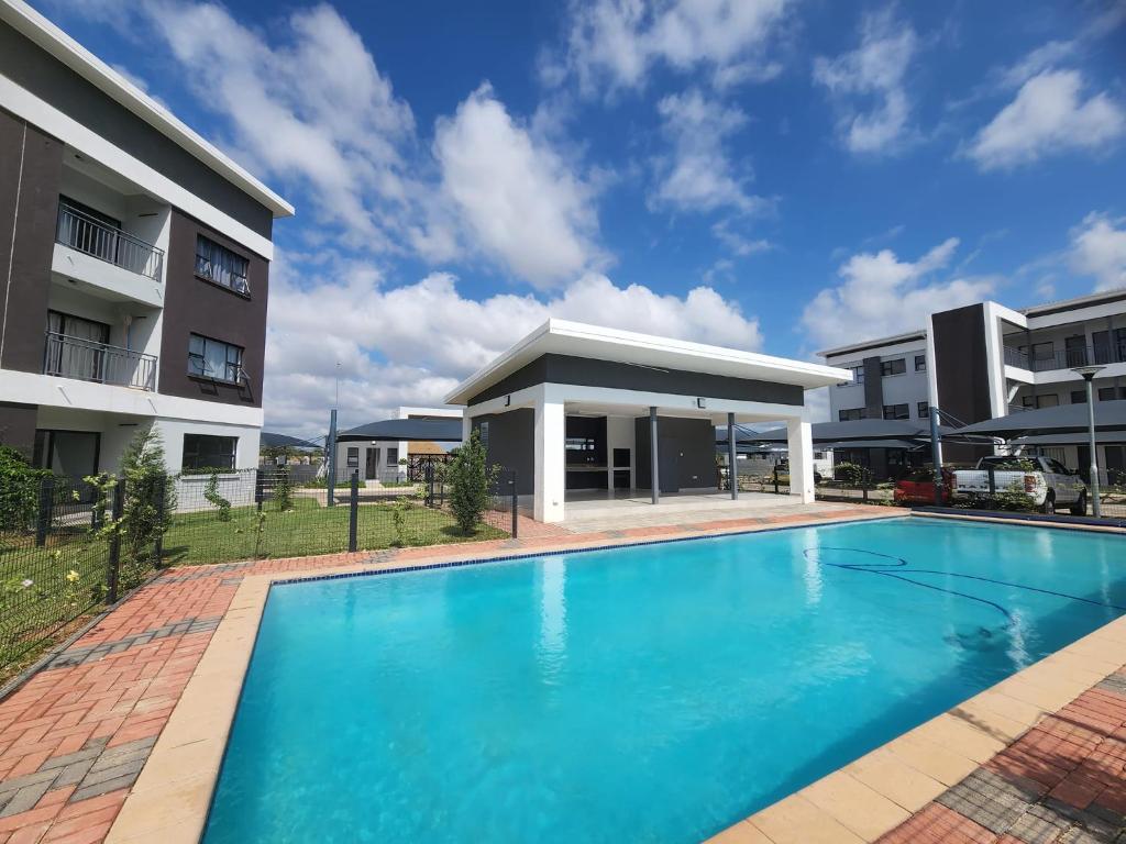 a swimming pool in front of a building at Zanaya Apartments in Gaborone