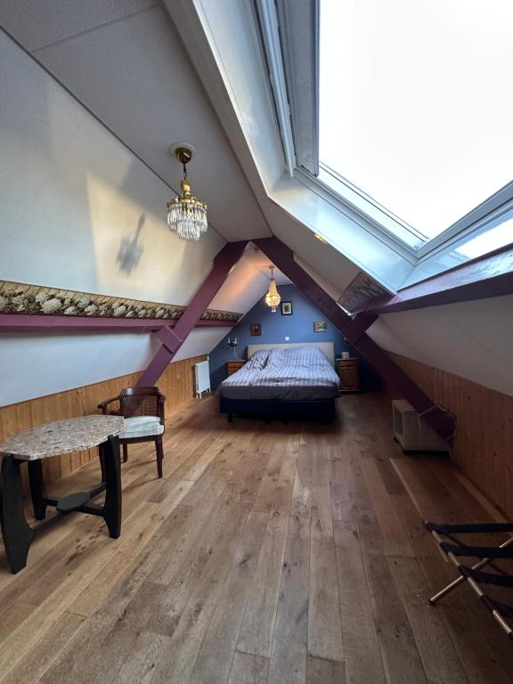 a attic bedroom with a bed and a skylight at Het Kraaienest in Zaandam