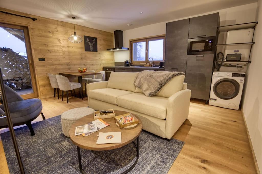 ein Wohnzimmer mit einem Sofa und einem Tisch in der Unterkunft Superbe appartement dans luxueux chalet Mt Charvin in Crest-Voland