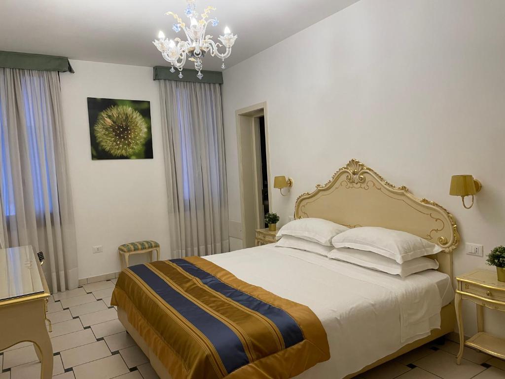 una camera con letto e lampadario a braccio di Rio del Piombo Suites a Venezia