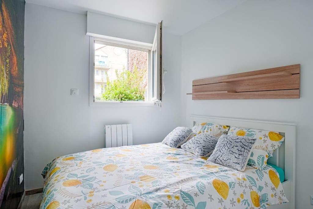 a bedroom with a bed and a window at LeRouget : Hypercentre / Jardin aménagé / Hamak in Moissy-Cramayel