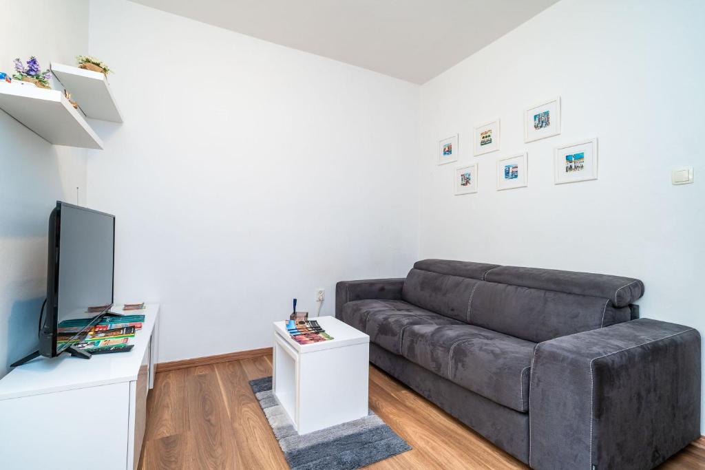 ein Wohnzimmer mit einem Sofa und einem TV in der Unterkunft Apartment Joky in Dubrovnik
