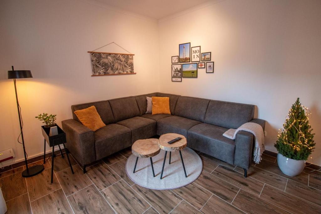 un soggiorno con divano marrone e tavolo di Das Posthaus - Amt a Greetsiel