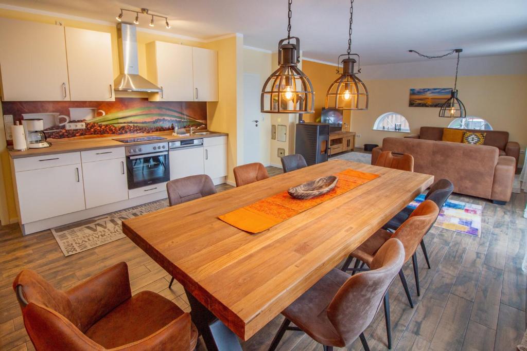 uma cozinha e sala de jantar com uma mesa de madeira e cadeiras em Huus Viskert em Krummhörn
