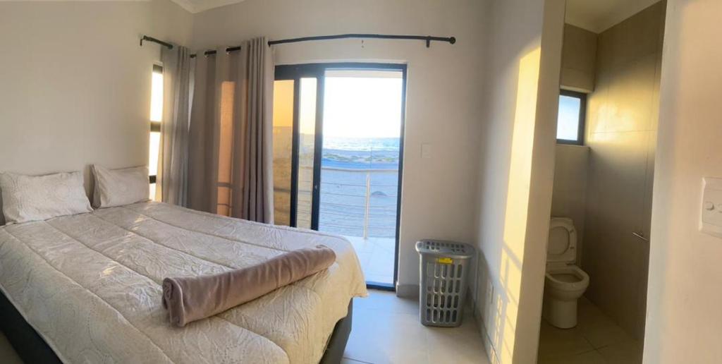 a bedroom with a large bed and a large window at 074DB on Dune Lark in Walvis Bay