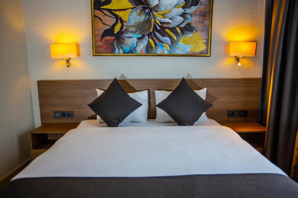 a bedroom with a white bed with two pillows at Istanbul Park Hotel in Tuzla