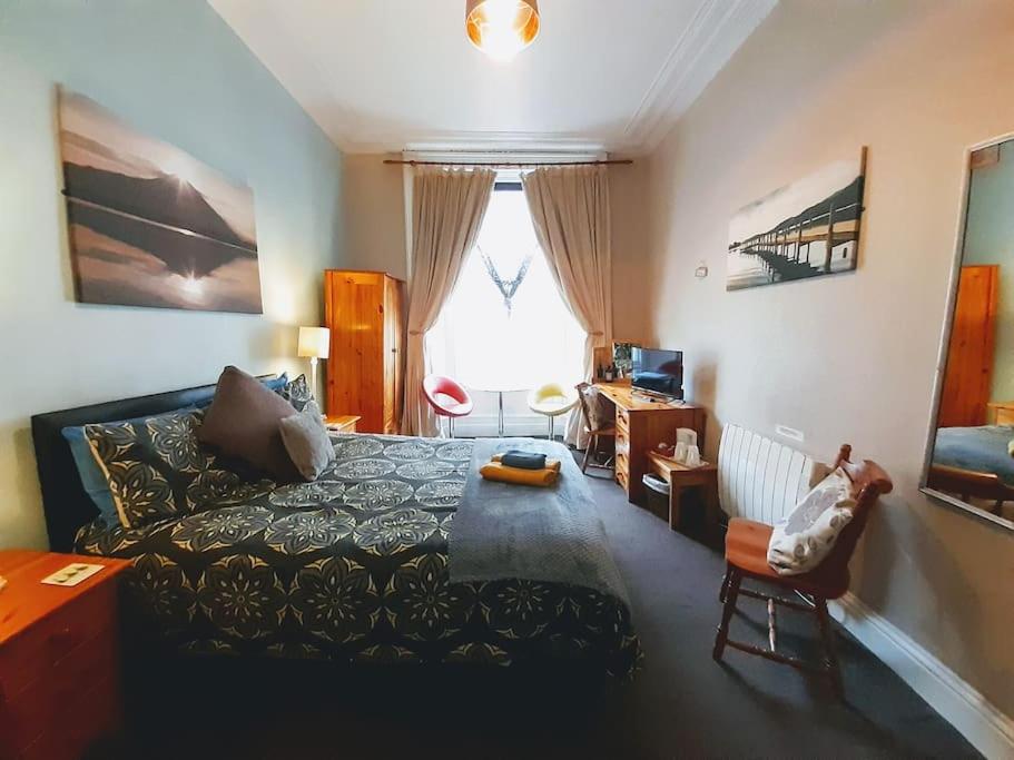 a living room with a bed and a window at aabAlree Guest House in Dundee