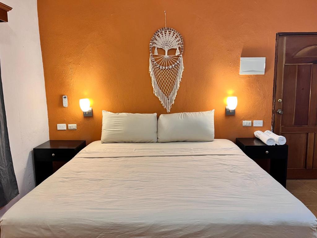 um quarto com uma cama com duas mesas de cabeceira e uma cabeceira em Tumben Kuxtal Tulum em Tulum