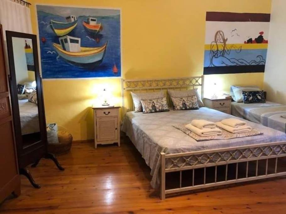 a bedroom with a bed and a painting of boats at Rita' s House Glossa Skopelos in Glossa