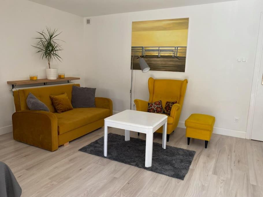 a living room with a couch and a table and a chair at Sopocki apartament i taras in Sopot