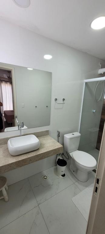 une salle de bain avec un lavabo et des toilettes dans l'établissement Casa Completa 01 com AR - Encantos de Arraial, à Arraial do Cabo
