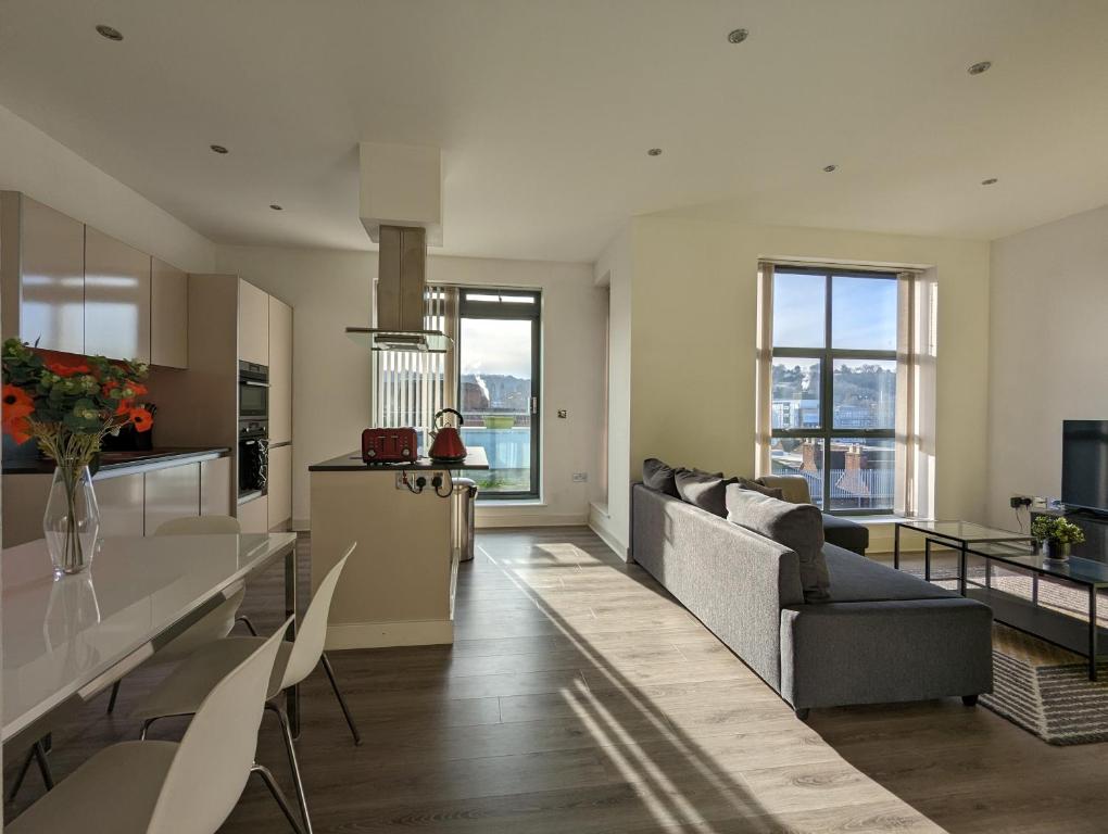 a kitchen and living room with a couch and chairs at Bankside by Wycombe Apartments in High Wycombe