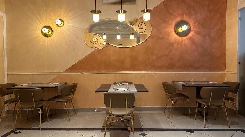 a restaurant with tables and chairs and a mirror at Hotel Roma in Bologna
