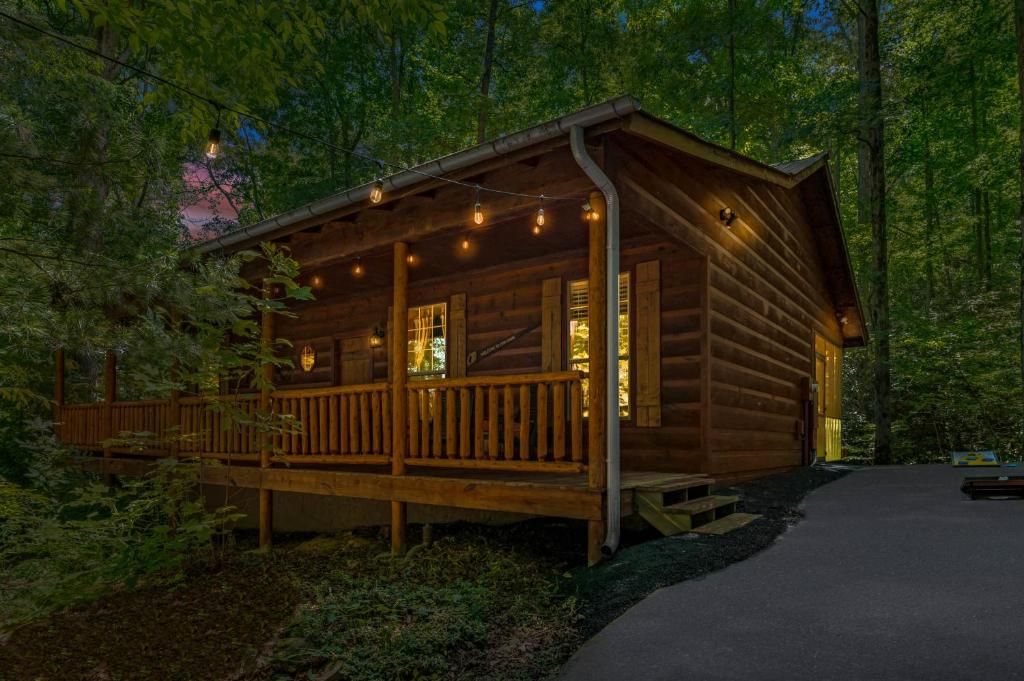 a log cabin in the woods with lights on it at Dreamy Cabin & Outdoor Oasis! Mins to Nat'l Park! in Townsend