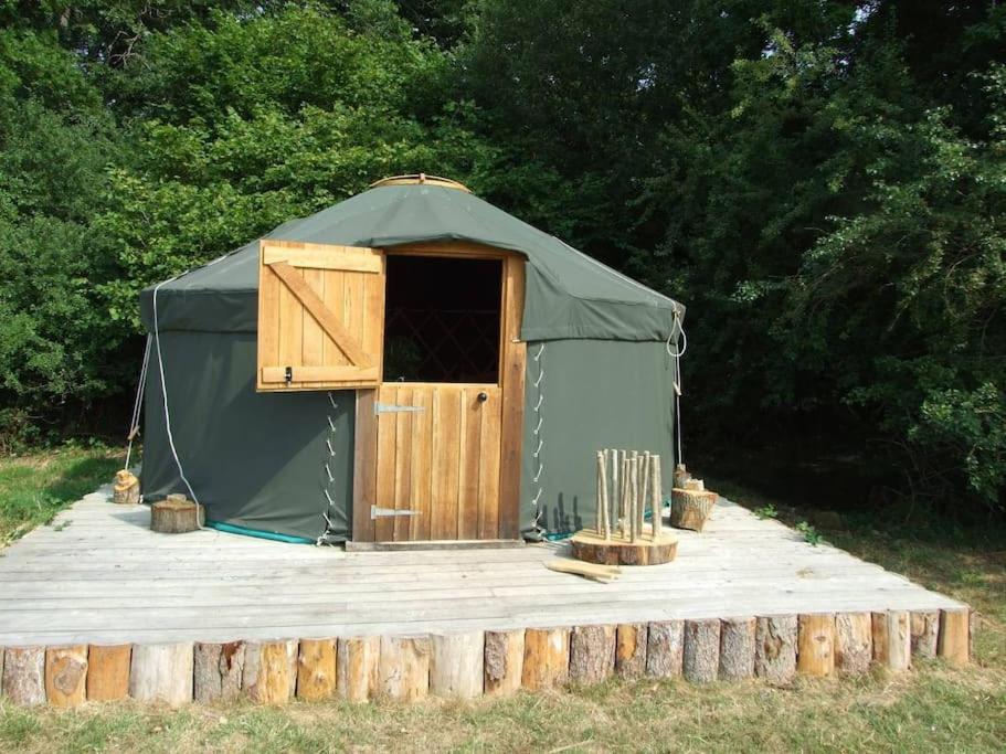 'Oak' Yurt in West Sussex countryside في Fernhurst: خيمة خضراء فيها باب ومجموعة من الخفافيش