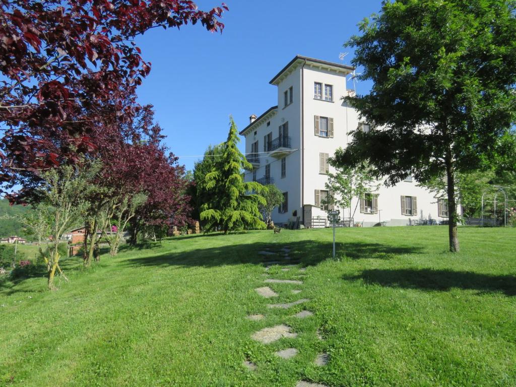 a building in the middle of a field with trees at Rose e Cioccolato B&B in Borgo Val di Taro
