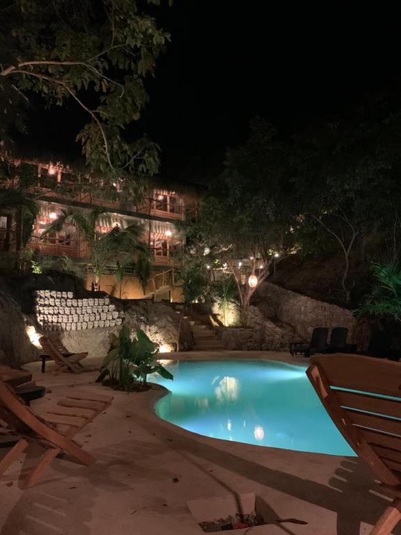 a swimming pool at night with lights at COCOS HOTEL in Zipolite