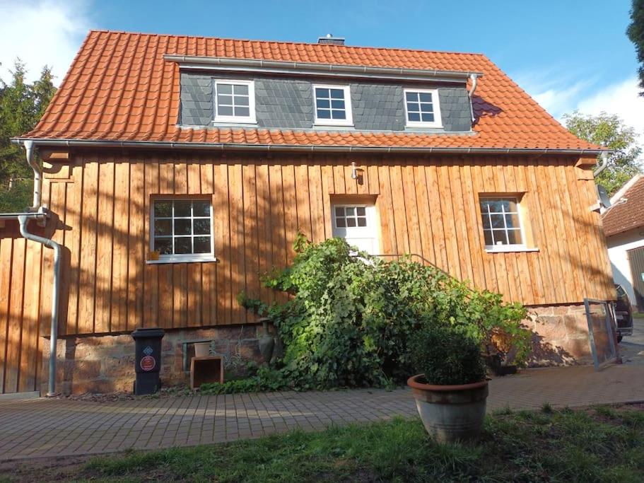 uma casa de madeira com um telhado laranja em Ferienhaus Naturparadies Rhön em Willmars