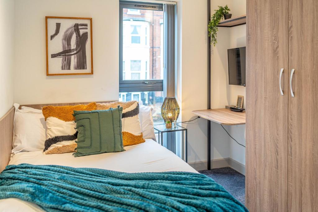Un dormitorio con una cama con una manta azul encima. en Stylish Studio Apartment with Free Parking in Wolverhampton 5min walk to City Centre, en Wolverhampton