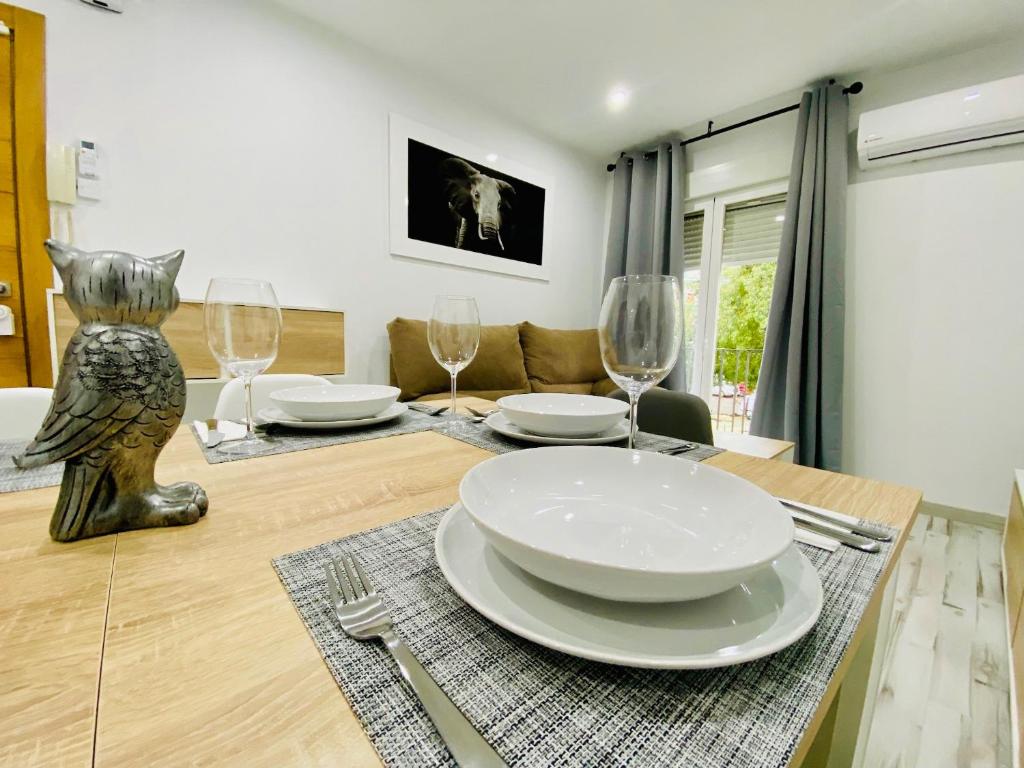 a dining room with a table with plates and wine glasses at COSTASOL PLAZA - PREMIUM CLASS - Apartamento céntrico moderno - 3BED 2ROOM 6PEOPLE - in Córdoba