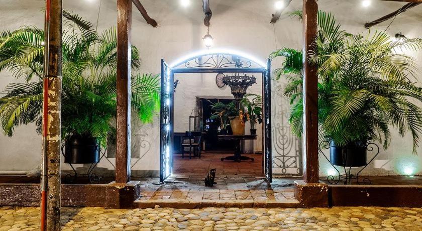 an open door to a room with two palm trees at Hotel Infinito La Casona in Villavieja