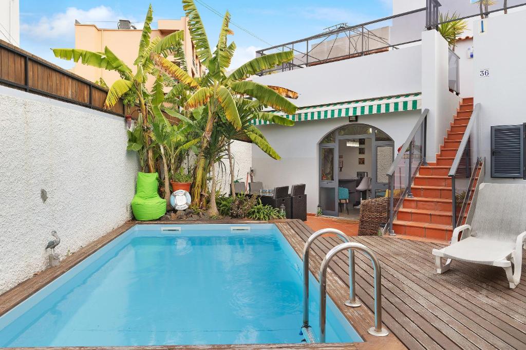 a swimming pool in the backyard of a house at Villa Garajau House in Caniço