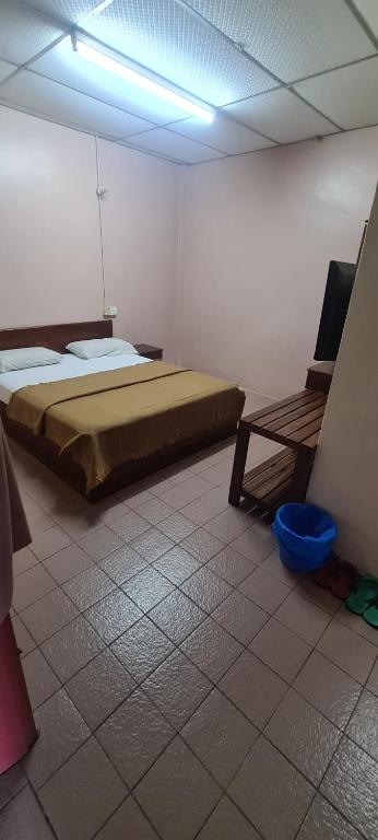 1 dormitorio con 1 cama y 1 silla en una habitación en East Coast Hotel, en Kuantan