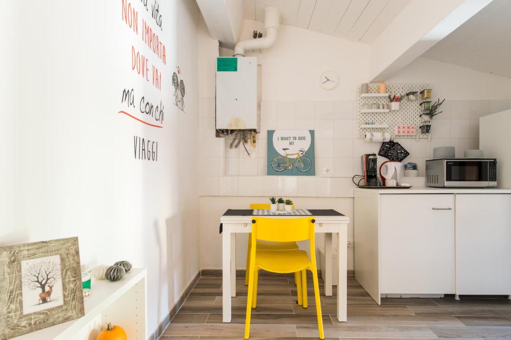 a kitchen with a desk and a yellow chair at Centrale APT con terrazza a 5min dal Pitti! - HomeUnity in Florence