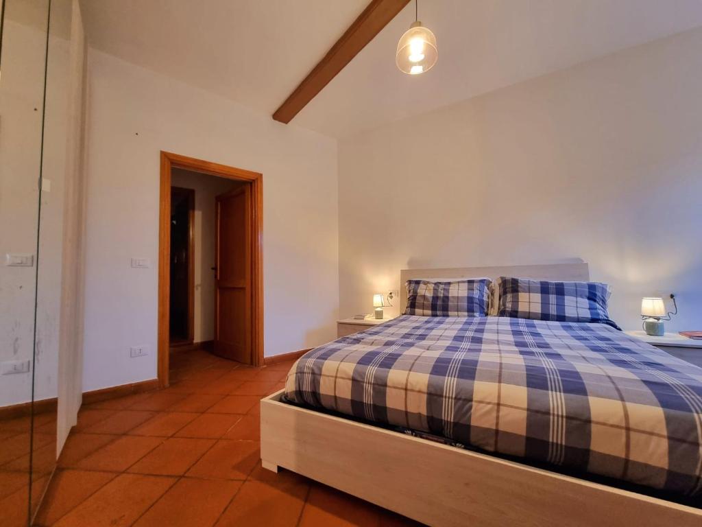 a bedroom with a bed with a blue and white plaid at Il Rustico Moderno del Centro di Portoferraio - Goelba in Portoferraio