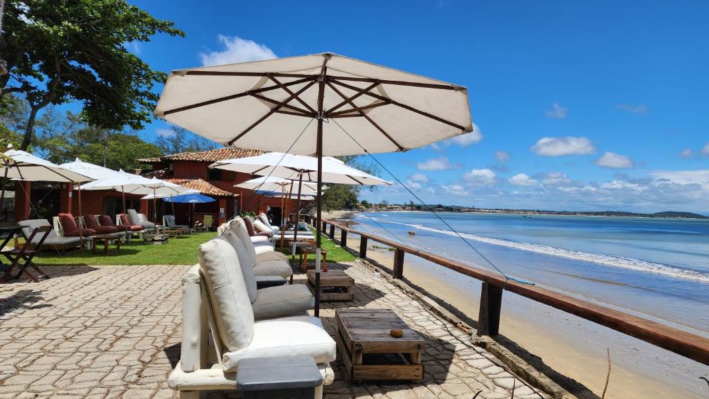 a row of chairs and umbrellas on a beach at Nativa Búzios in Búzios