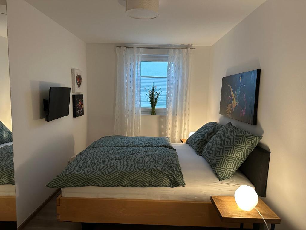 a small bedroom with a bed and a window at Ferienwohnung Fischerweg in Bodensdorf