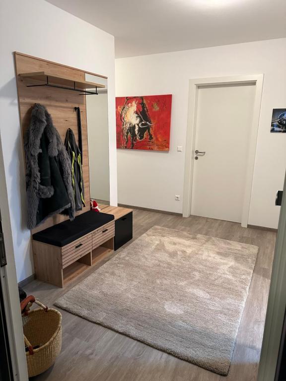 a living room with a large rug and a door at Ferienwohnung Fischerweg in Bodensdorf