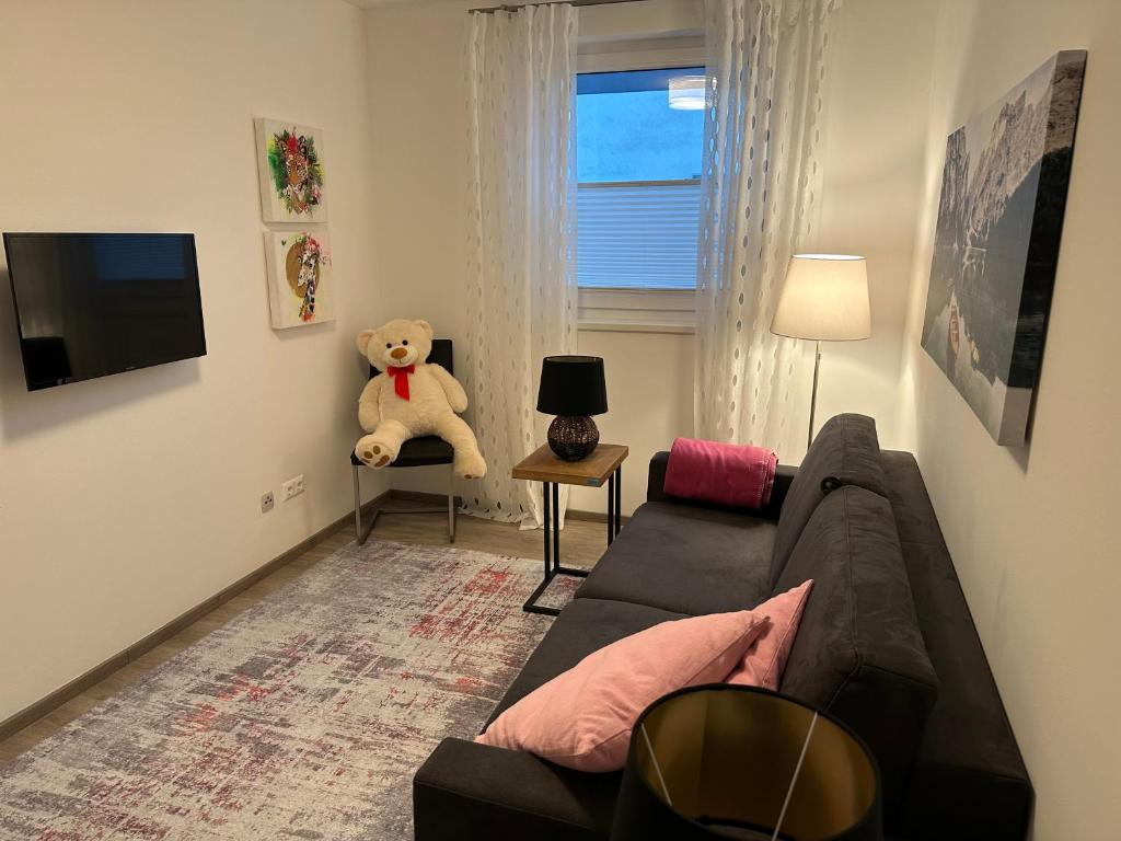 a living room with a couch and a teddy bear at Ferienwohnung Fischerweg in Bodensdorf